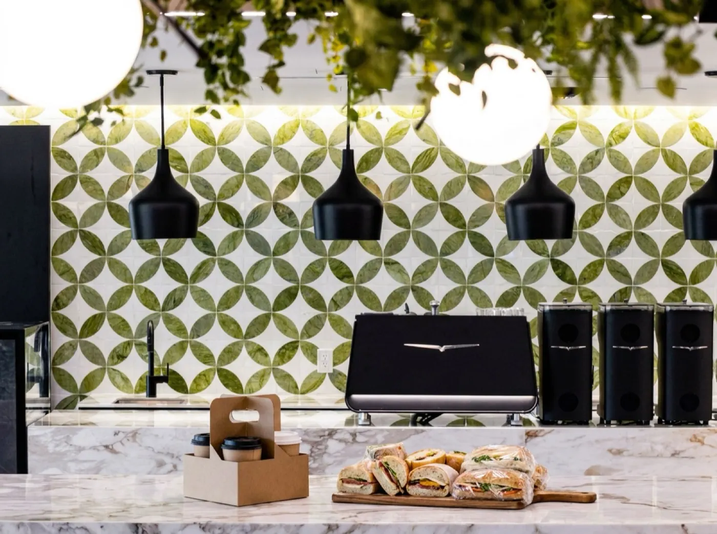 Fresh sandwiches and coffee carrier on the marble bar at Café 295
